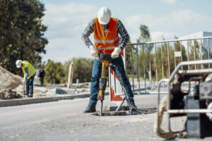 worker-in-reflective-vest-with-drill-repairing-str-2021-08-26-15-45-36-utc.jpg